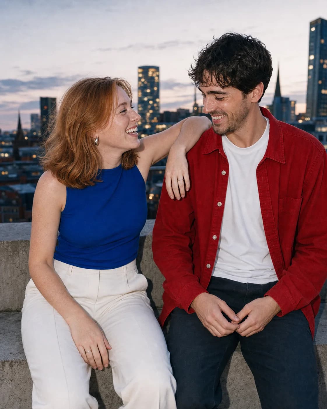 Phoebe and Max laughing together on the rooftop at dusk